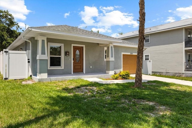2906 E Columbus Dr, Tampa, FL 33605 - single story home with covered porch, a front yard, stucco siding, and a garage