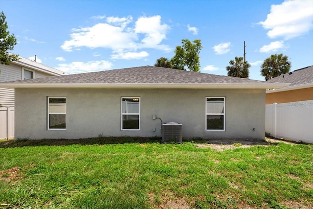 2906 E Columbus Dr, Tampa, FL 33605 - back of house with a yard, fence, stucco siding, a shingled roof, and central AC unit