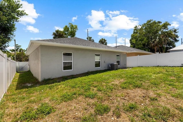 2906 E Columbus Dr, Tampa, FL 33605 - back of property featuring a fenced backyard, stucco siding, a yard, and central AC