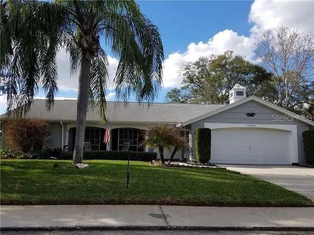 12303 Fieldstone Ln, Hudson, FL 34667 - ranch-style house featuring an attached garage, concrete driveway, and a front yard