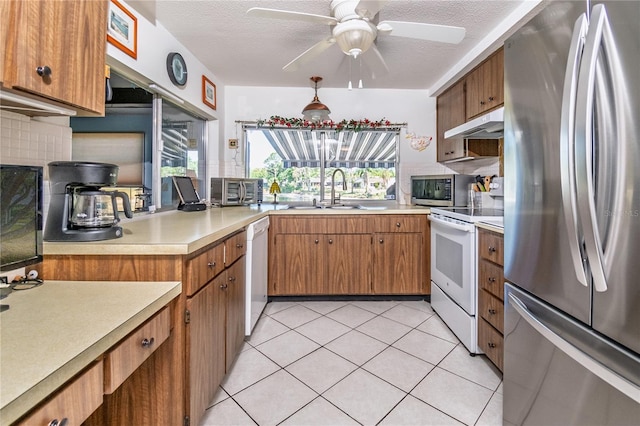 12303 Fieldstone Ln, Hudson, FL 34667 - kitchen with stainless steel appliances, a sink, light countertops, under cabinet range hood, and a ceiling fan