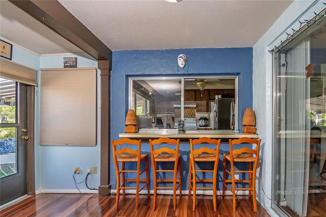 12303 Fieldstone Ln, Hudson, FL 34667 - bar with freestanding refrigerator, wood finished floors, exhaust hood, baseboards, and electric range oven