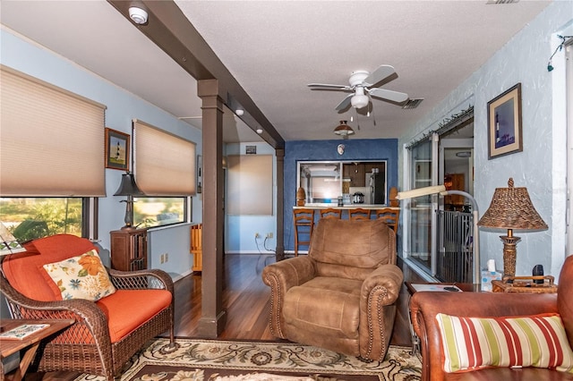 12303 Fieldstone Ln, Hudson, FL 34667 - living room featuring ceiling fan, wood finished floors, ornate columns, and a textured ceiling