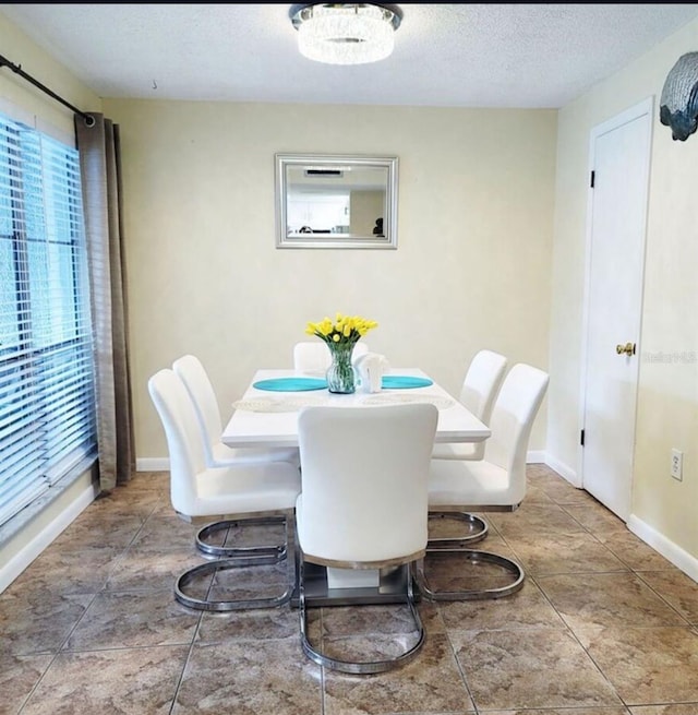 323 Rex Pl Unit G, Madeira Beach, FL 33708 - dining room with a textured ceiling and tile patterned flooring