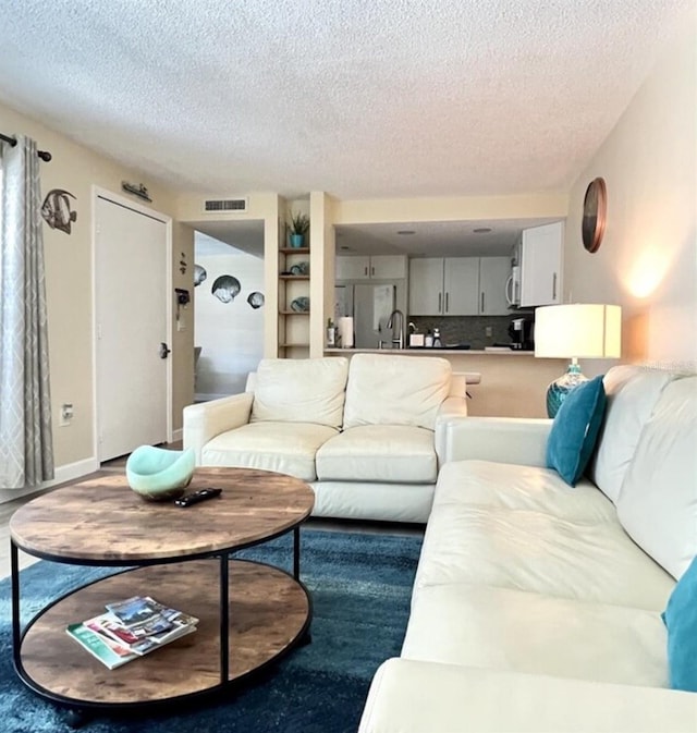 323 Rex Pl Unit G, Madeira Beach, FL 33708 - living room featuring a textured ceiling