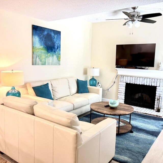 323 Rex Pl Unit G, Madeira Beach, FL 33708 - living room featuring wood finished floors, ceiling fan, a textured ceiling, and a brick fireplace