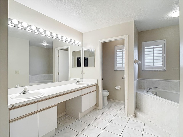 bathroom with toilet, a garden tub, double vanity, and a sink