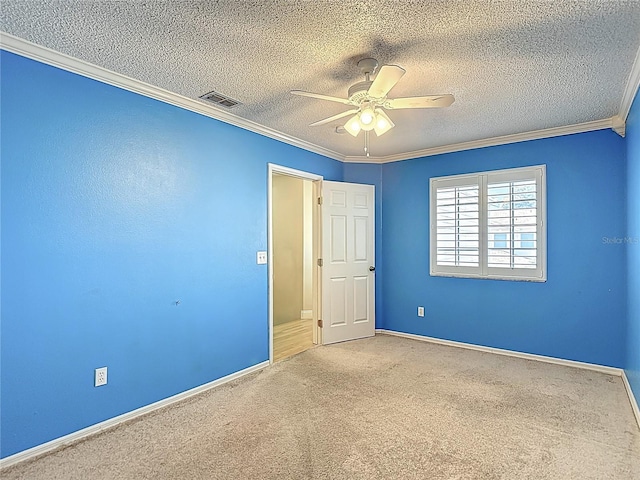 unfurnished bedroom with carpet, a textured ceiling, visible vents, baseboards, and ornamental molding