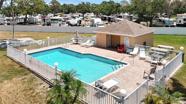 pool with a yard, fence, and a patio area