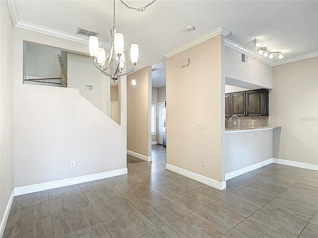 unfurnished dining area with a chandelier, a textured ceiling, crown molding, tile patterned flooring, and baseboards