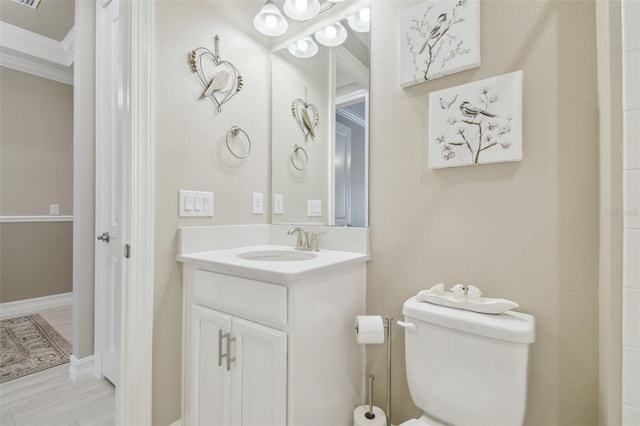 bathroom featuring crown molding, vanity, and toilet