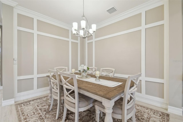 dining room featuring a chandelier, ornamental molding, and baseboards