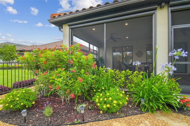 view of side of property with a tiled roof and fence