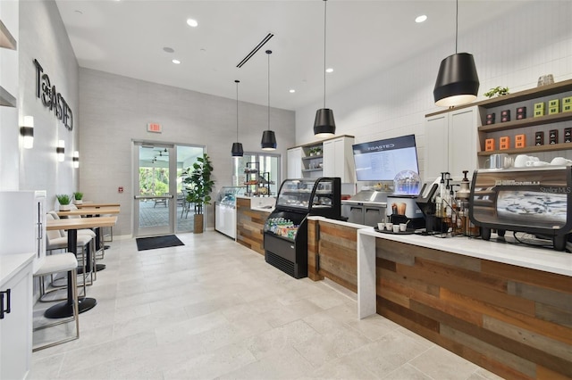 kitchen featuring a high ceiling, recessed lighting, open shelves, pendant lighting, and white cabinetry