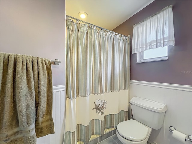 9679 W Pimpernel Ln, Crystal River, FL 34429 - bathroom featuring wainscoting, curtained shower, and toilet
