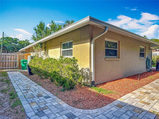 9679 W Pimpernel Ln, Crystal River, FL 34429 - view of side of property featuring stucco siding, fence, and a patio area