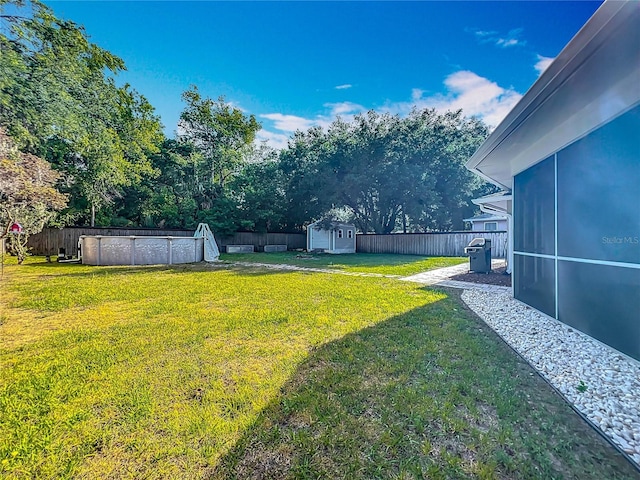 9679 W Pimpernel Ln, Crystal River, FL 34429 - view of yard featuring a storage shed, a swimming pool, a sunroom, a fenced backyard, and an outbuilding
