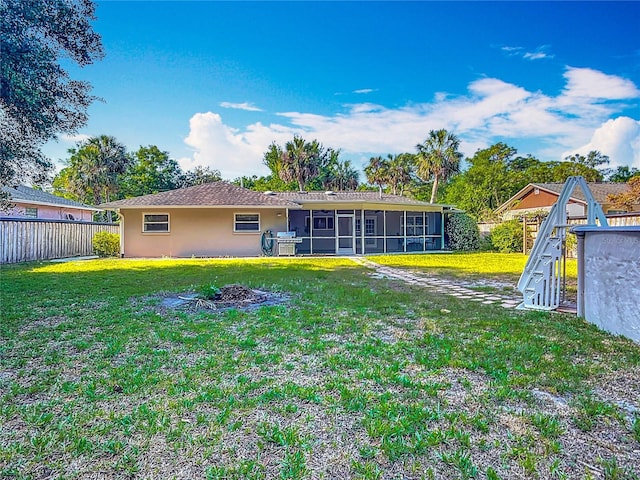 9679 W Pimpernel Ln, Crystal River, FL 34429 - rear view of property with a sunroom, stucco siding, fence, and a lawn