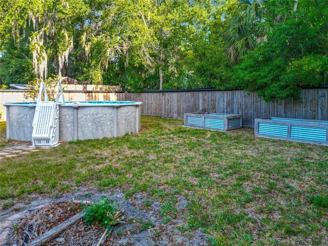 9679 W Pimpernel Ln, Crystal River, FL 34429 - view of yard featuring a fenced backyard, a fenced in pool, and a garden