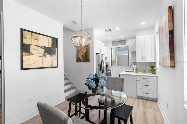 8723 Palm Ranches Pl, Tampa, FL 33614 - dining space with light wood-type flooring, a chandelier, recessed lighting, stairway, and baseboards