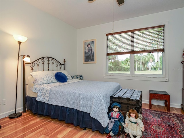 bedroom with baseboards, a ceiling fan, and wood finished floors