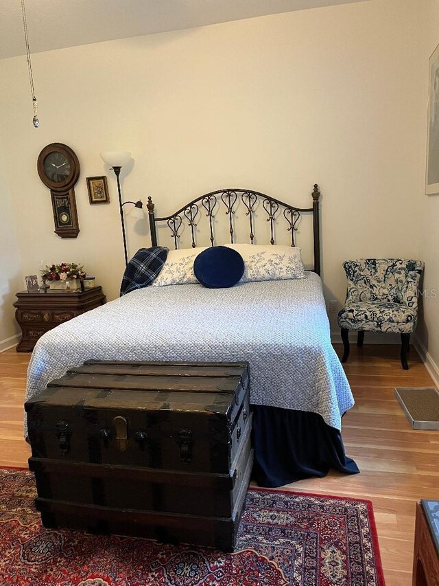 bedroom with baseboards and wood finished floors