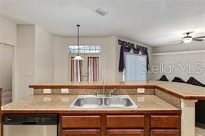 kitchen featuring stainless steel dishwasher, light countertops, and brown cabinets