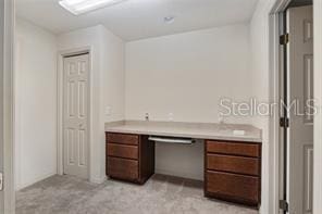 unfurnished office featuring light carpet and built in study area
