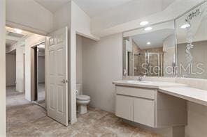 bathroom with a stall shower, vanity, and toilet