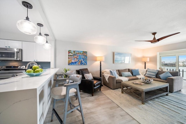 868 Bayway Blvd Unit 206, Clearwater Beach, FL 33767 - living room with light wood finished floors and ceiling fan