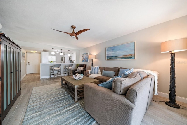 868 Bayway Blvd Unit 206, Clearwater Beach, FL 33767 - living area with light wood-style floors, a ceiling fan, and baseboards