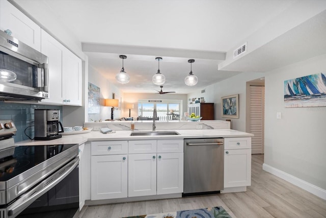 868 Bayway Blvd Unit 206, Clearwater Beach, FL 33767 - kitchen featuring appliances with stainless steel finishes, light wood-style floors, ceiling fan, and white cabinets