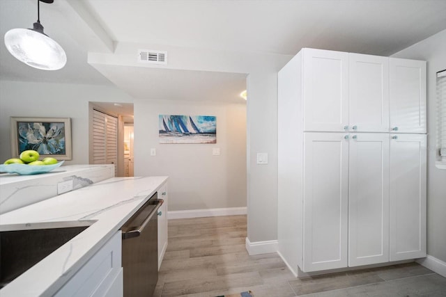 868 Bayway Blvd Unit 206, Clearwater Beach, FL 33767 - kitchen featuring light stone countertops, light wood finished floors, stainless steel dishwasher, white cabinets, and baseboards
