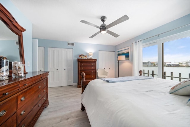 868 Bayway Blvd Unit 206, Clearwater Beach, FL 33767 - bedroom featuring light wood-style flooring, two closets, ceiling fan, and a water view