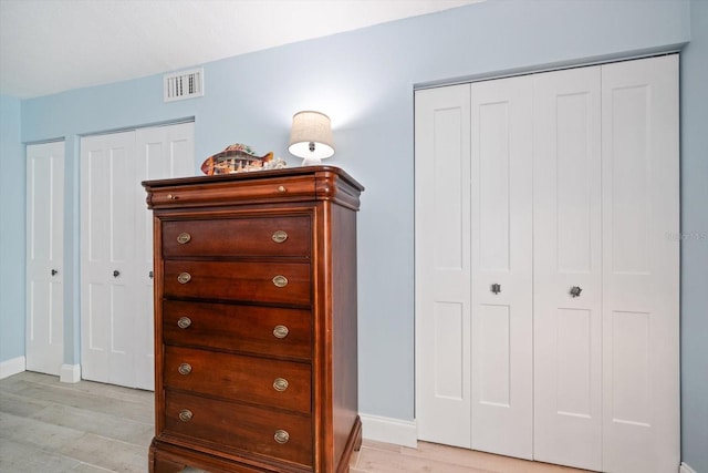 868 Bayway Blvd Unit 206, Clearwater Beach, FL 33767 - bedroom with light wood-style floors, baseboards, and two closets