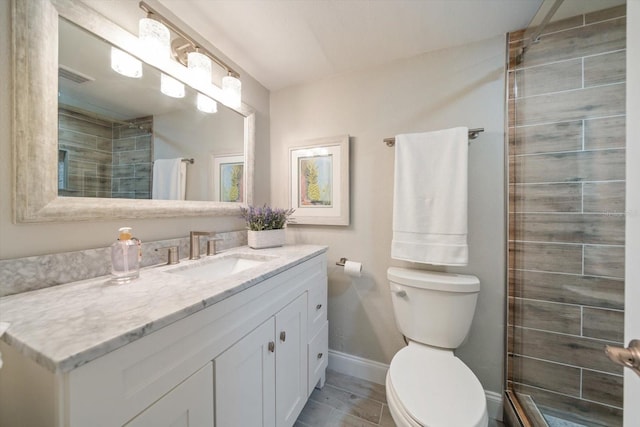 868 Bayway Blvd Unit 206, Clearwater Beach, FL 33767 - bathroom featuring toilet, a tile shower, vanity, and baseboards