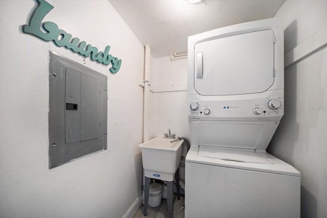 868 Bayway Blvd Unit 206, Clearwater Beach, FL 33767 - laundry room featuring stacked washing machine and dryer, electric panel, a sink, and baseboards