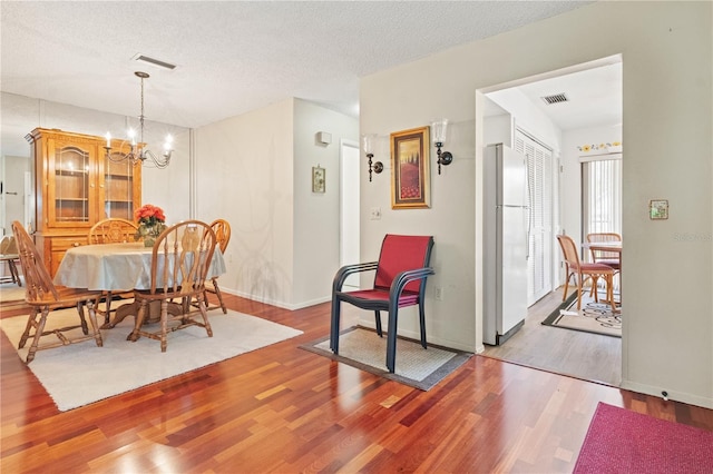 12804 Wedgewood Way Unit C, Hudson, FL 34667 - dining space featuring a chandelier, wood finished floors, baseboards, and a textured ceiling