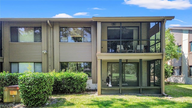 12804 Wedgewood Way Unit C, Hudson, FL 34667 - back of house with a sunroom and a lawn