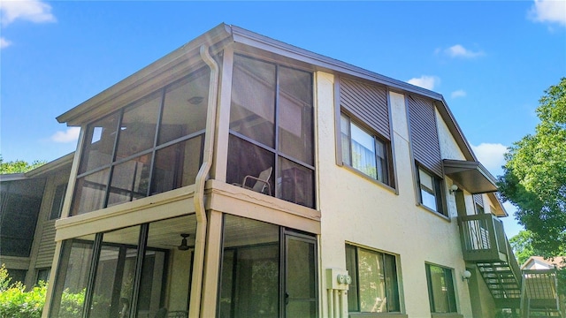 12804 Wedgewood Way Unit C, Hudson, FL 34667 - view of home's exterior featuring a sunroom, stucco siding, and stairs