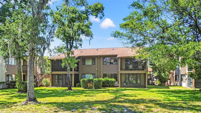 12804 Wedgewood Way Unit C, Hudson, FL 34667 - rear view of house with a sunroom, stairs, and a yard