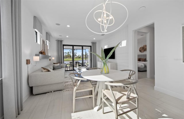 dining space with a chandelier, baseboards, and recessed lighting