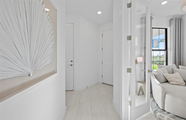 hall with recessed lighting and baseboards