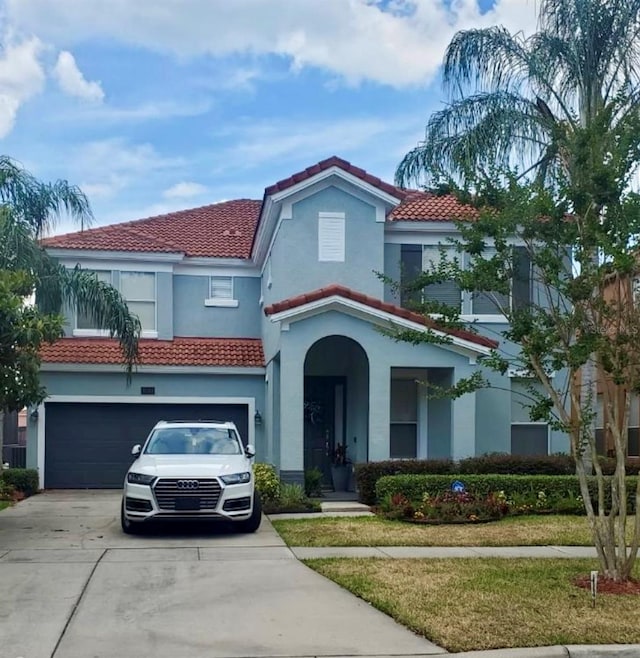 1030 Marcello Blvd, Kissimmee, FL 34746 - mediterranean / spanish-style home featuring an attached garage, stucco siding, a tile roof, concrete driveway, and a front yard