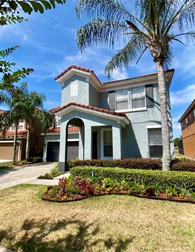 1030 Marcello Blvd, Kissimmee, FL 34746 - mediterranean / spanish house with driveway, stucco siding, a tiled roof, and a front lawn