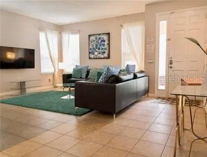 1030 Marcello Blvd, Kissimmee, FL 34746 - living room featuring baseboards and light tile patterned floors