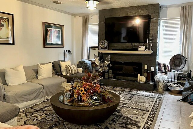1030 Marcello Blvd, Kissimmee, FL 34746 - living area featuring ornamental molding, a healthy amount of sunlight, visible vents, and a large fireplace