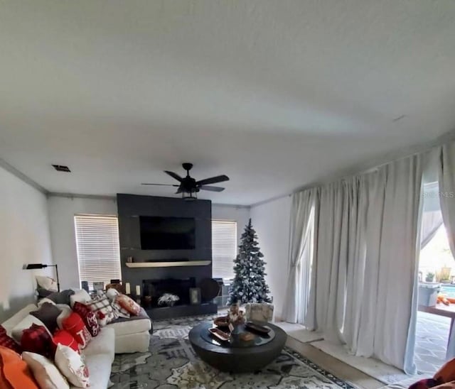 1030 Marcello Blvd, Kissimmee, FL 34746 - living room featuring a large fireplace, ceiling fan, and visible vents