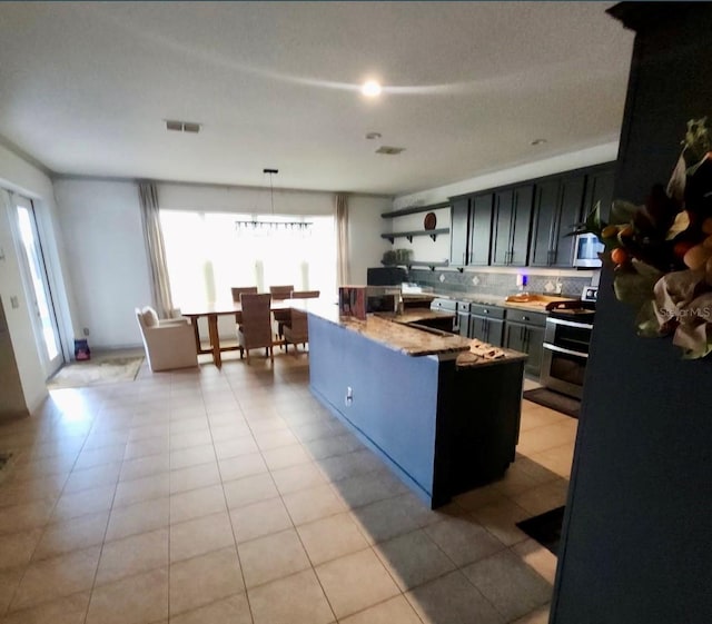 1030 Marcello Blvd, Kissimmee, FL 34746 - kitchen with hanging light fixtures, visible vents, light tile patterned flooring, tasteful backsplash, and appliances with stainless steel finishes