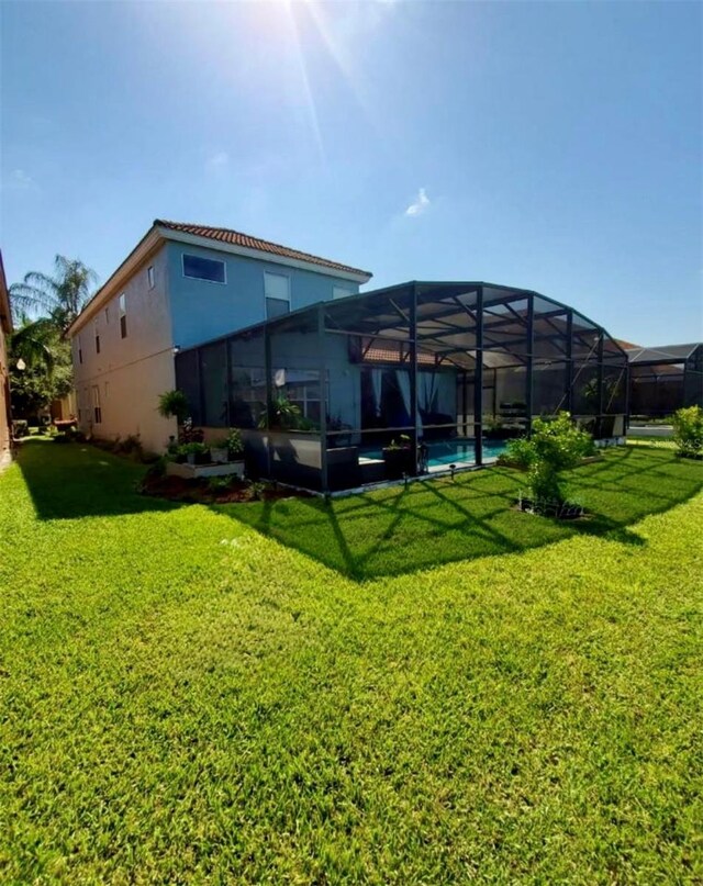 1030 Marcello Blvd, Kissimmee, FL 34746 - rear view of house with a yard, stucco siding, an outdoor pool, and a lanai